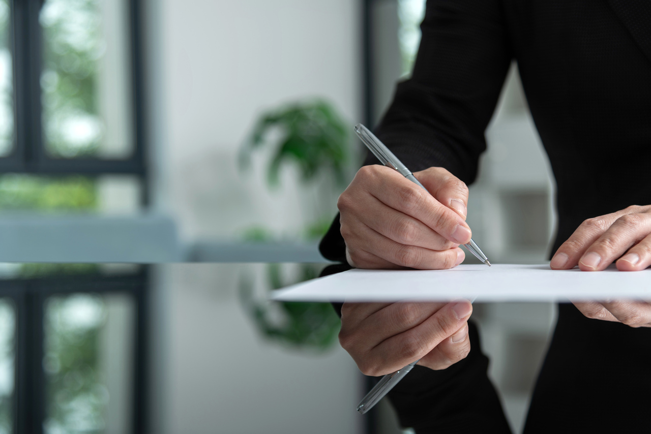 Geschäftsfrau schreibt handschriftlich auf Papier